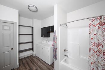 A white bathroom with a shower curtain and a white cabinet.